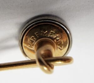 Gold pin with engraved "Krementz" text.