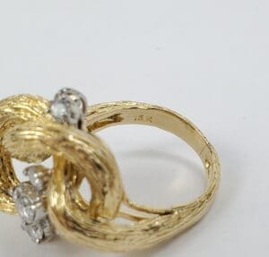 Gold ring with intricate design and diamonds.