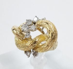 Gold ring with diamonds and textured design.