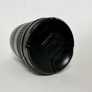 Camera lens with black cap on table.