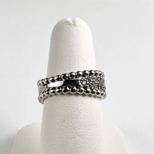 Silver ring with beaded design on display.