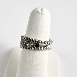 Silver rings displayed on a white stand.