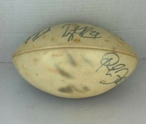 Autographed football with multiple signatures displayed.