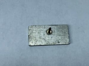 Rectangular metal plate with a protruding screw.