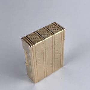 Gold-tone rectangular lighter with textured design.