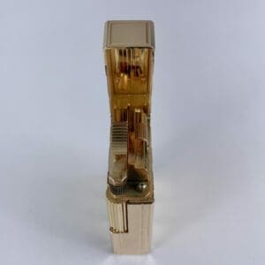 Gold lighter with open lid, vertical view.