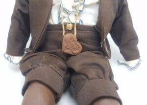 Doll in brown outfit with necklace.