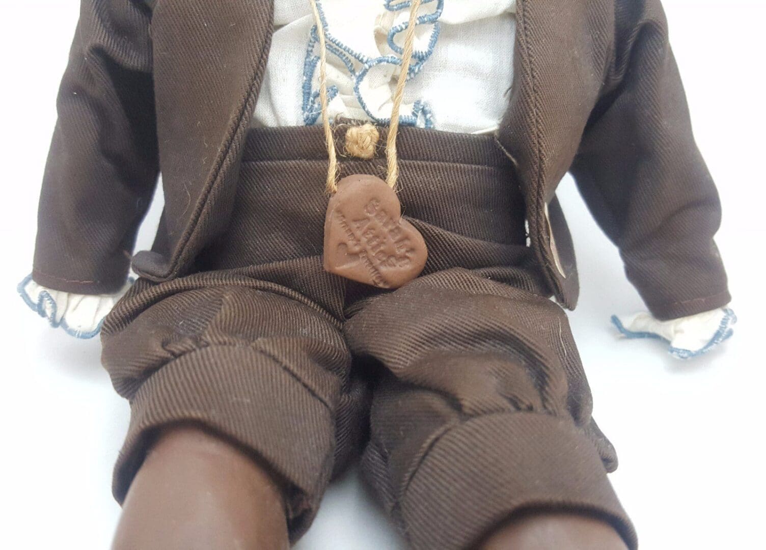 Doll in brown outfit with necklace.