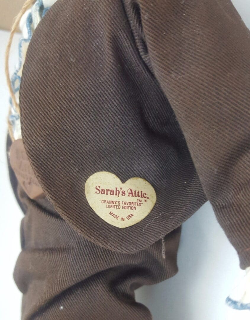 Heart-shaped tag on brown fabric.