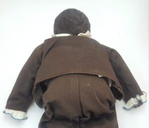 Back of a doll in brown clothes.