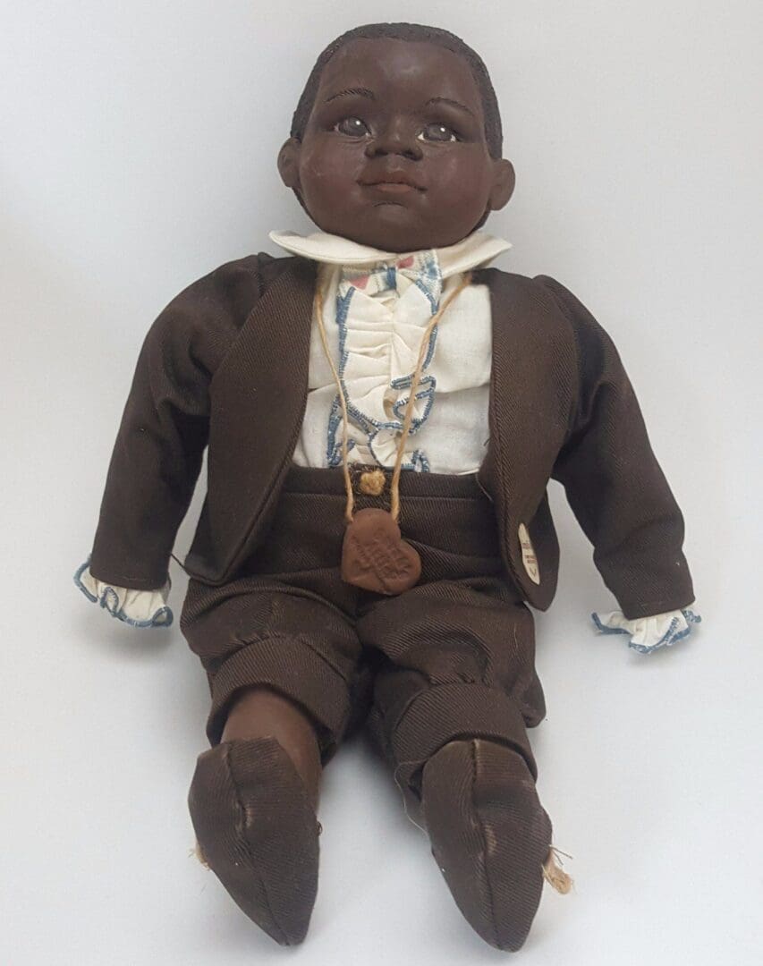 Doll wearing brown suit and white shirt.