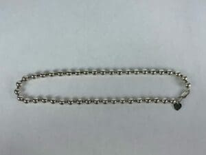Silver beaded necklace with heart charm.