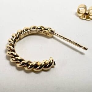 Gold twisted hoop earring with backing.