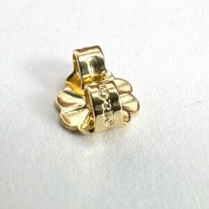 Gold flower-shaped metal bead on white.