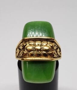 Green jade ring with gold floral design.