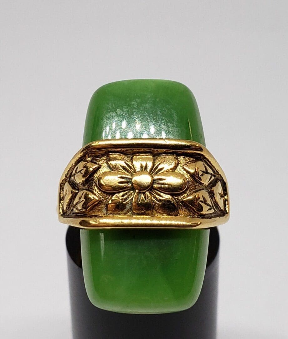 Green jade ring with gold floral design.