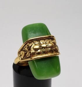 Gold floral ring with green stone.