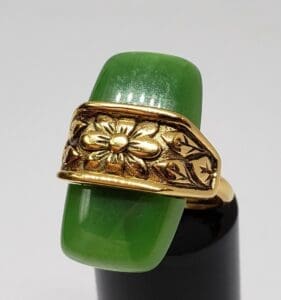 Gold floral ring with green stone.