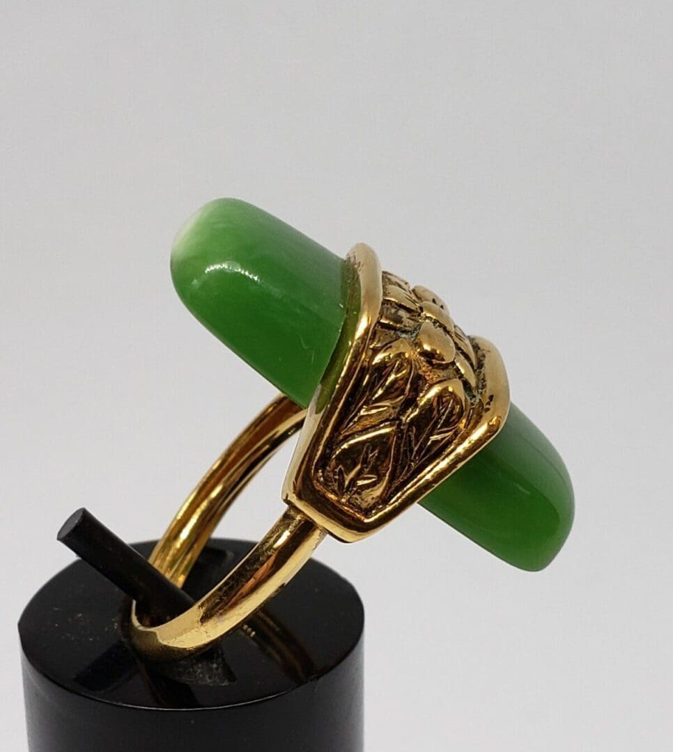 Gold ring with green gemstone detail.