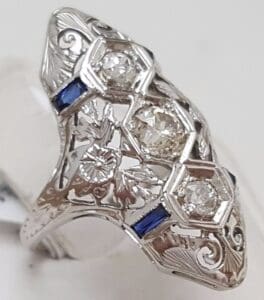 Ornate silver ring with diamonds and sapphires.