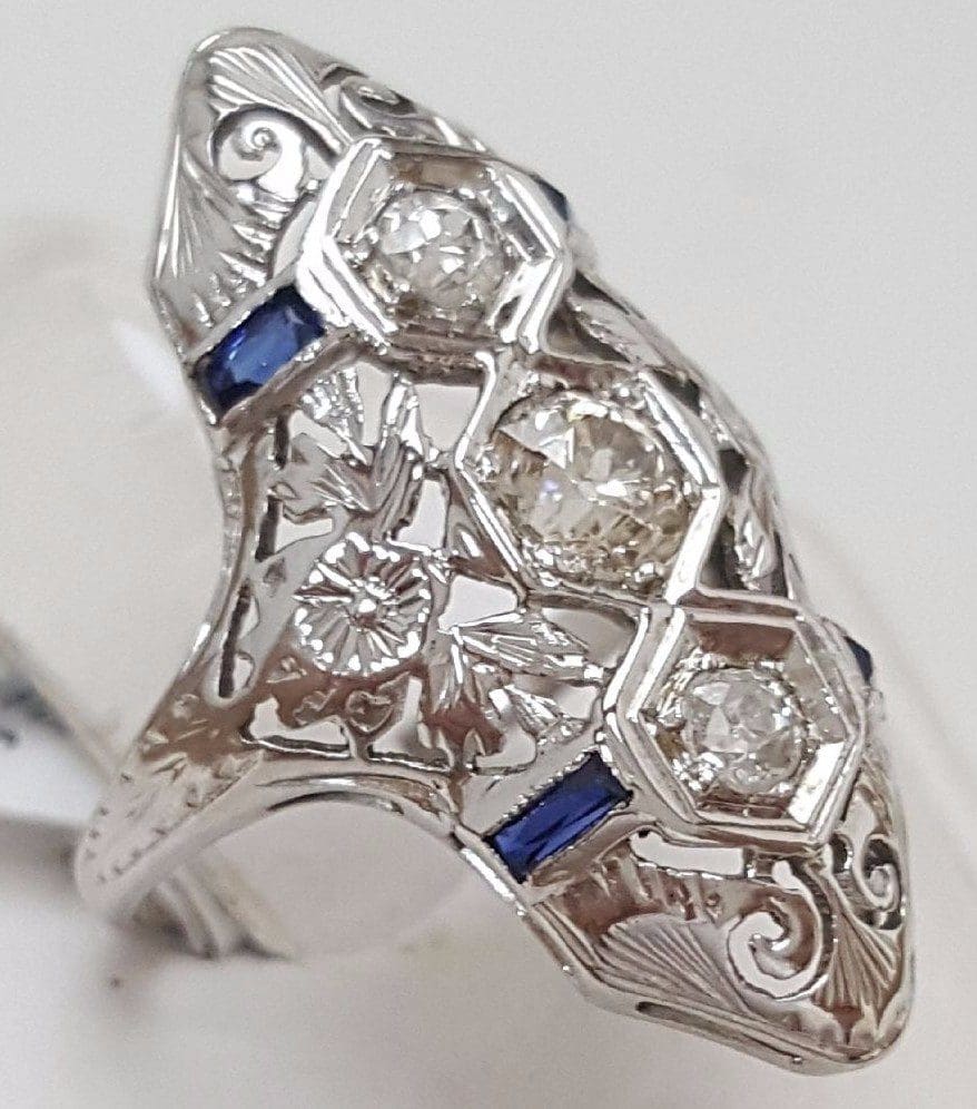 Ornate silver ring with diamonds and sapphires.