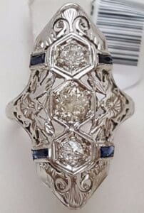 Ornate silver ring with three diamonds.