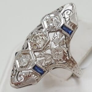 Ornate silver ring with diamonds and sapphires.