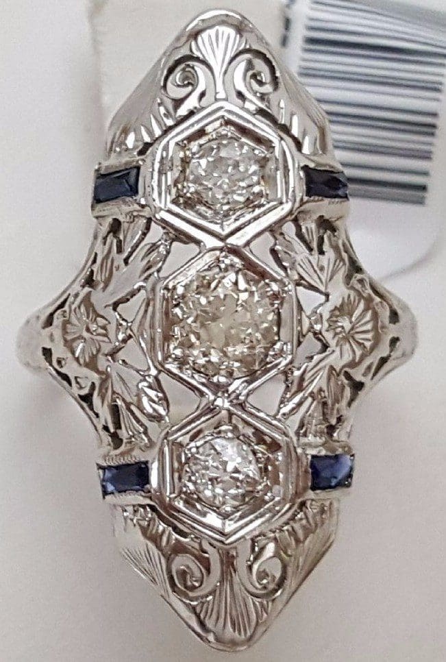 Ornate silver ring with three diamonds.
