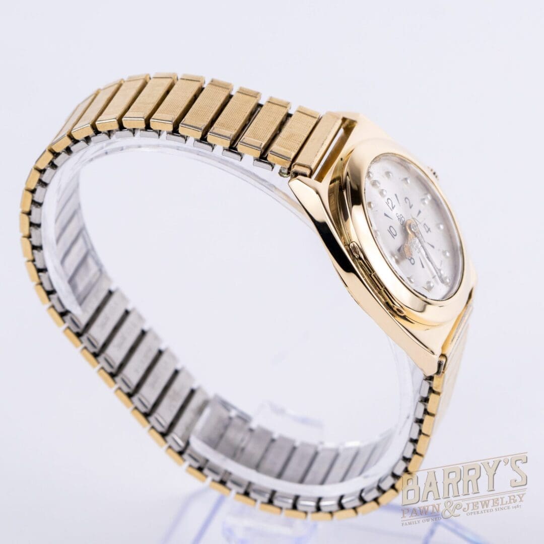 Gold and silver wristwatch on display stand.
