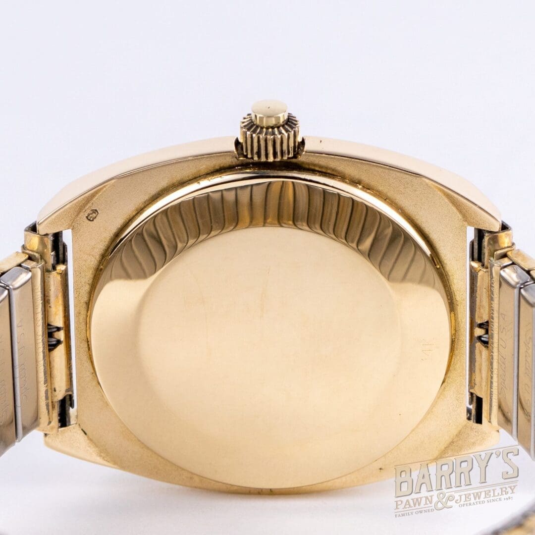 Gold wristwatch back with metal strap.