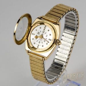 Gold wristwatch with open protective cover.