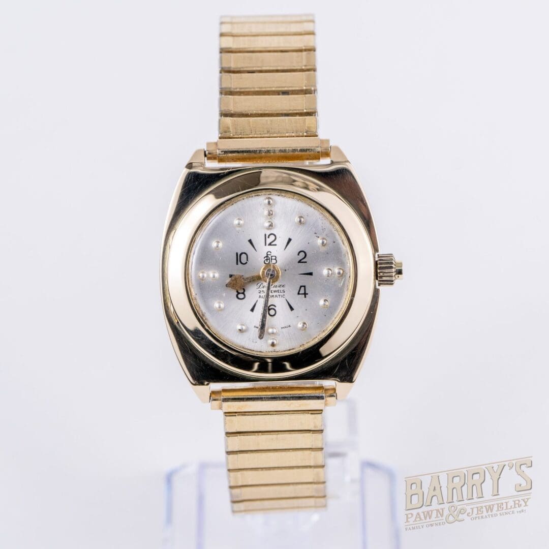 Gold wristwatch with a silver dial.