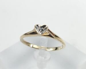 Gold ring with heart-shaped diamond setting.