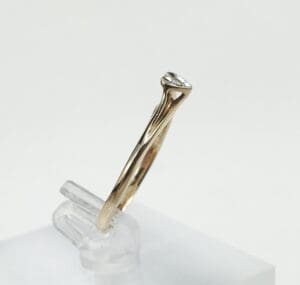 Gold ring with a clear gemstone displayed.