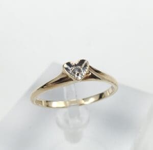 Gold ring with heart-shaped diamond centerpiece.