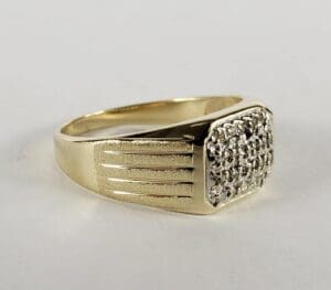 Gold ring with diamond-studded rectangular top.