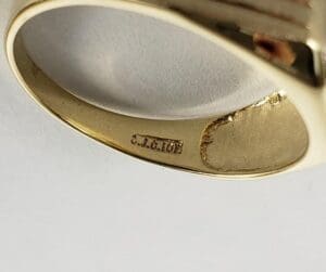 Gold ring with engraved text inside.