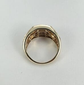 Gold ring with intricate design, side view.