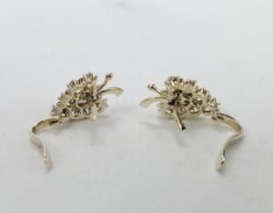 Gold decorative earrings on white background.