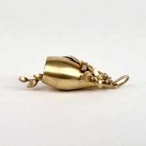 Gold bell pendant with floral design.