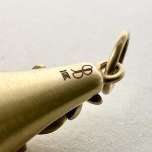 Gold pendant with engraved initials and ring.
