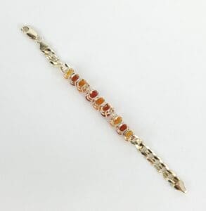 Gold bracelet with orange gemstones on display.
