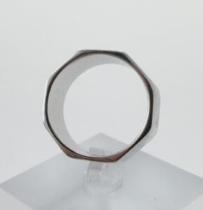 Octagonal silver ring on clear stand.