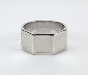 Silver hexagonal ring with textured design.