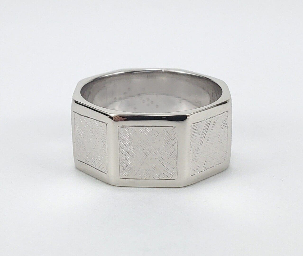 Silver hexagonal ring with textured design.