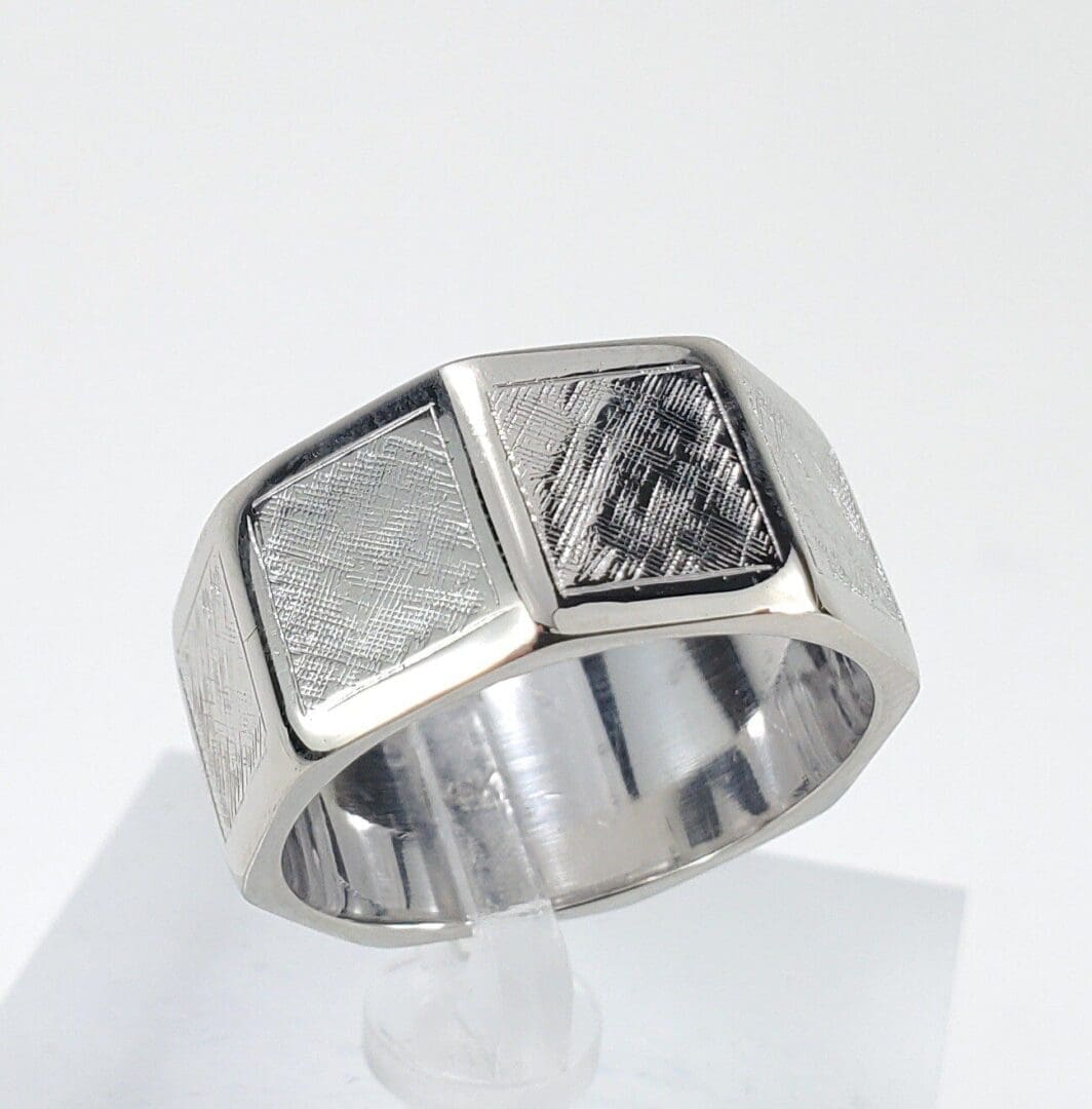 Silver ring with textured geometric design.