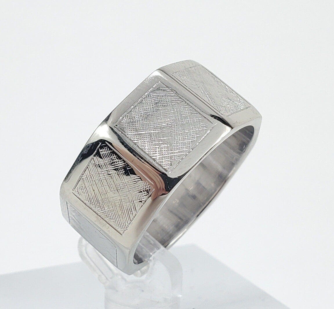 Silver ring with textured square design.