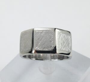 Silver ring with textured square design.