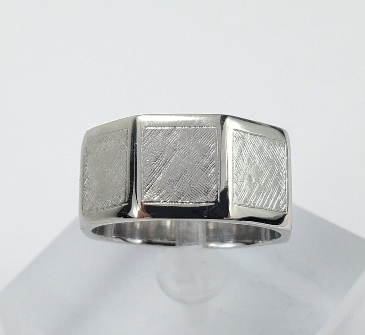 Silver ring with textured square design.