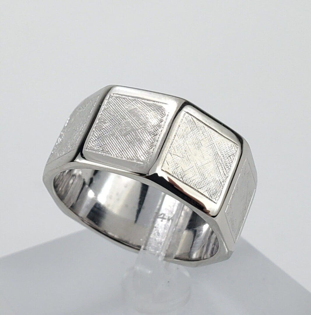 Silver ring with textured square design.